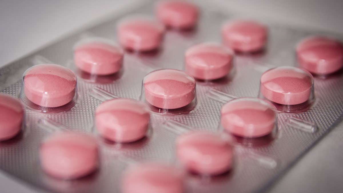 Pink tablets in a blister pack, emphasizing healthcare and medication concepts.