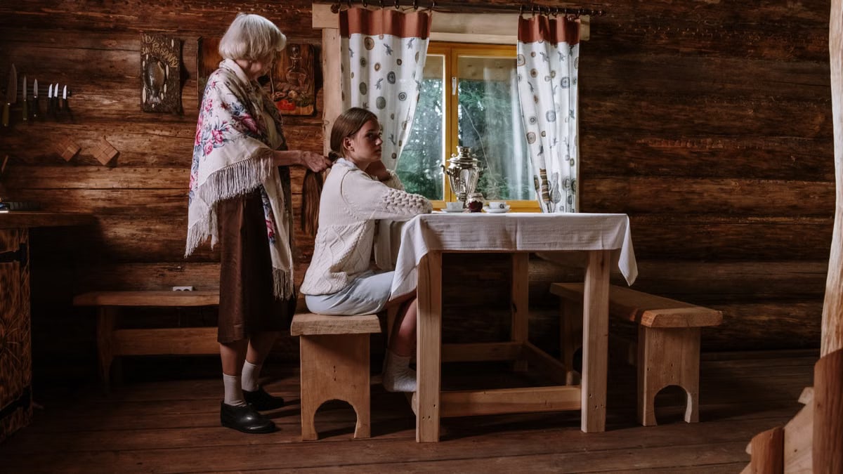 Warm interaction between granddaughter and grandmother in a cozy wooden cabin.